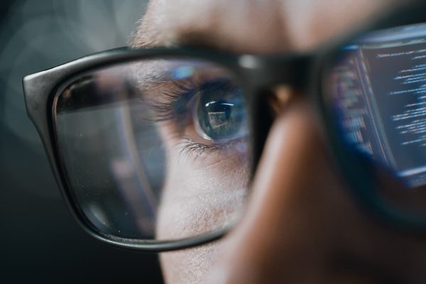 Close-up Portrait of Software Engineer Working on Computer, Line of Code Reflecting in Glasses. Developer Working on Innovative e-Commerce Application using Machine Learning, AI Algorithm, Big Data